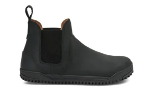 A black slip-on Chelsea Boot by Xero Shoes with elastic side panels, a pull tab at the back, rounded toe, and textured rubber sole. This simple design features visible stitching and a low heel—ideal for everyday use.